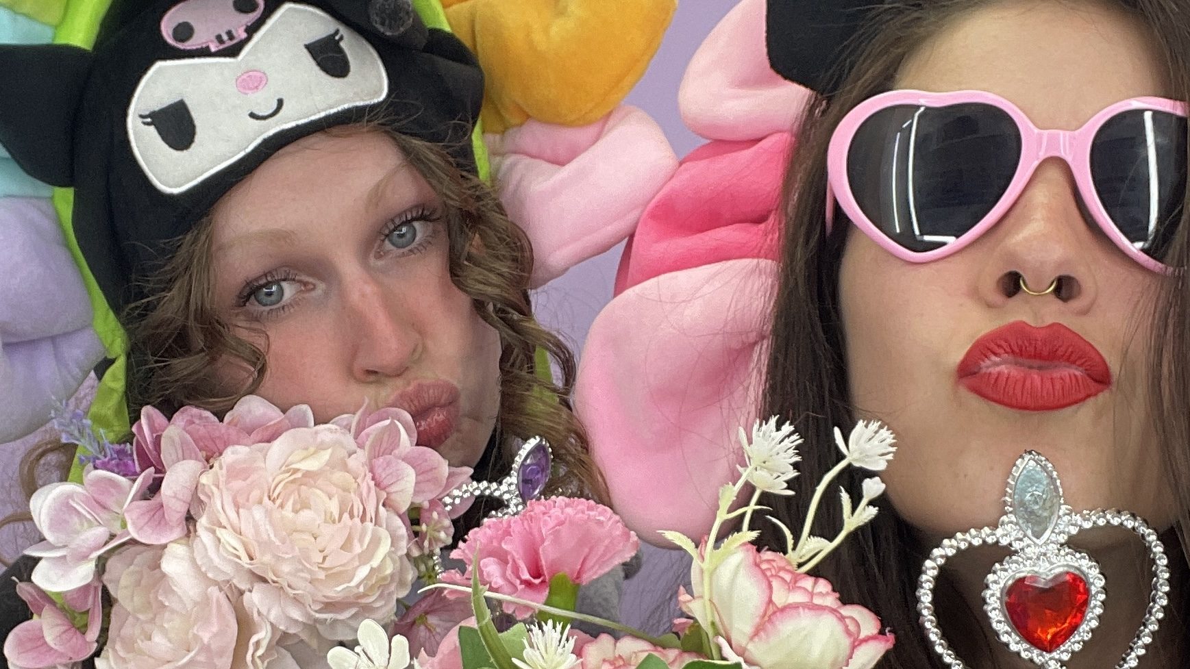 Photo de deux femmes avec des déguisements qui font un bisou avec leurs bouches.