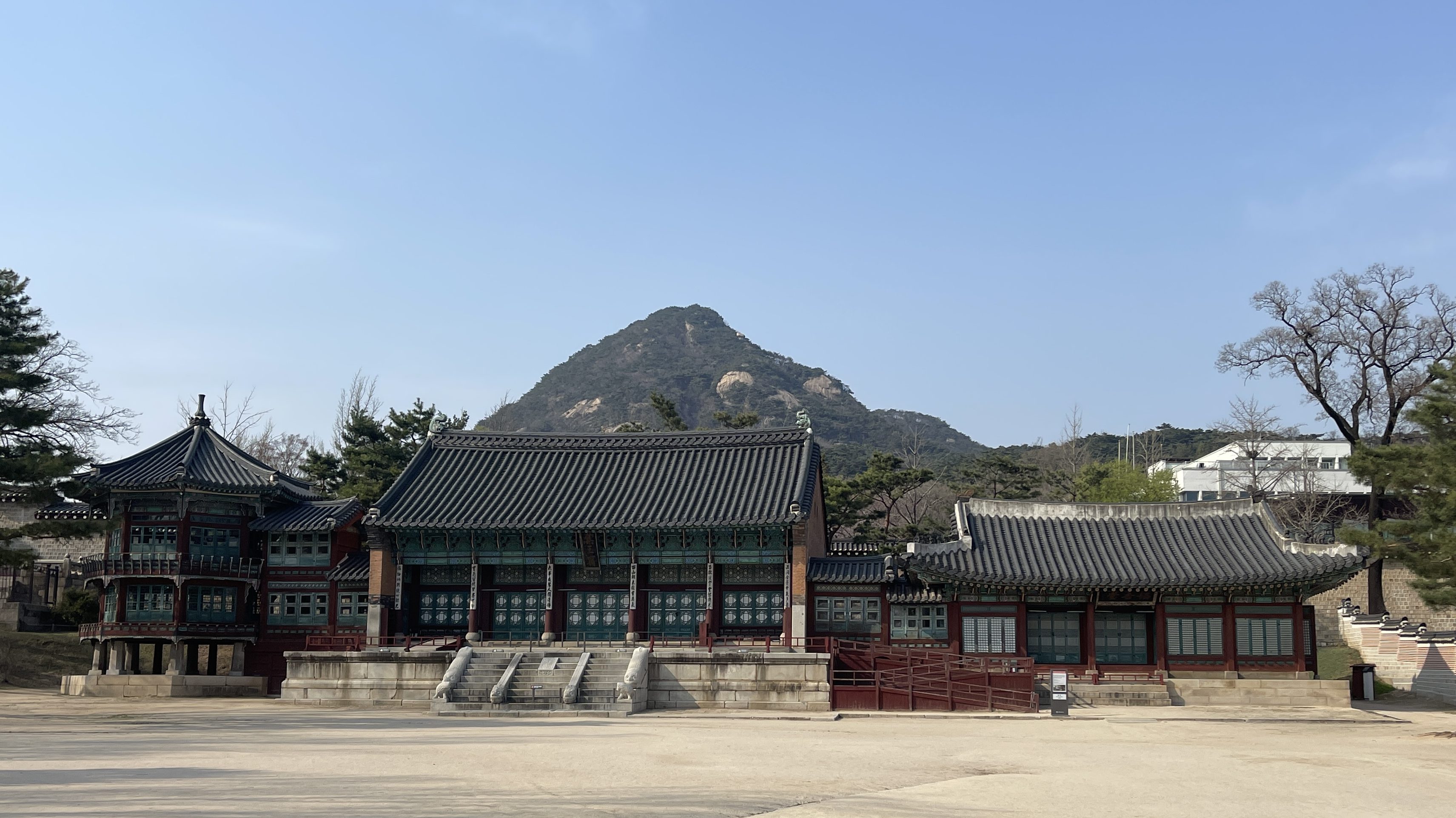Temple typique de la Corée du Sud, avec en fond des arbres et des montagnes.