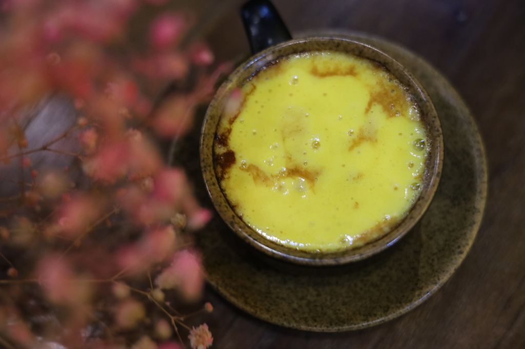 Tasse de café avec la présentation d'un egg coffee. La mousse sur le dessus est de couleur jaune.