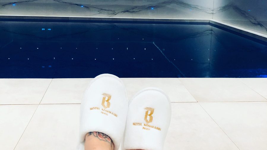 Personne en chaussons en face de la piscine d'un hotel parisien